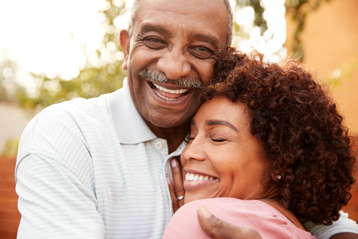 senior man enjoying his independence at a retirement community hugging his daughter
